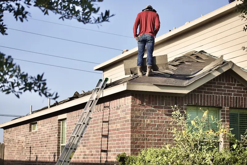 Professional roofer working on a residential roof in Warren Crossroads